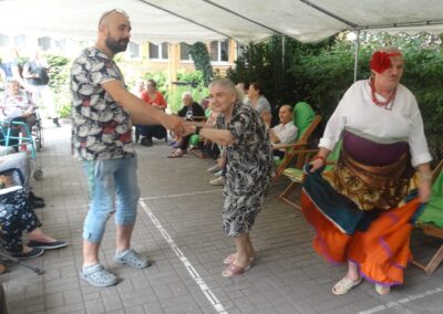 Wspólne tańce Pana Łukasza Wujca z Mieszkankami Panią Anią i Panią Basią, która ubarana jest w kolorowy strój cyganki